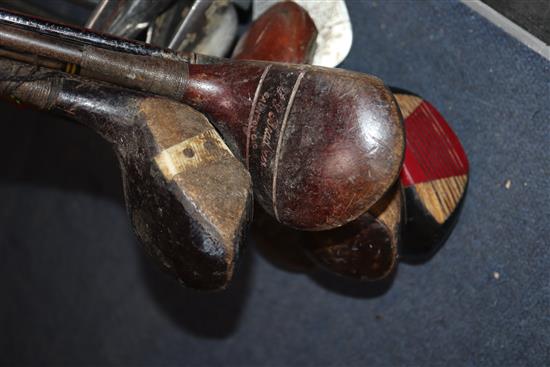 A collection of golf clubs, including woods and irons (makers including Whitcombe and Spalding)